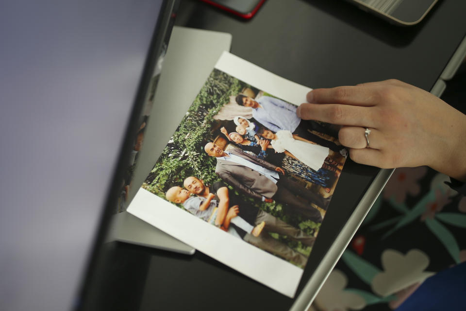 Uyghur Nursimangul Abdureshid, 34, shows a photograph of her family during an interview with The Associated Press in Istanbul, Turkey on May 4, 2022. Nearly one in 25 people in a county in the Uyghur heartland of China has been sentenced to prison on terrorism-related charges, in what is the highest known imprisonment rate in the world, an Associated Press review of leaked data shows. Abdureshid's brother, Memetali Abdureshid, who ran a car repair shop, was listed as being sentenced to 15 years and 11 months in prison on charges of "picking quarrels and provoking trouble” and “preparing to carry out terrorist activities." (AP Photo/Emrah Gurel)