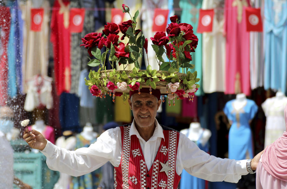 A flower seller is pictured at the old market in Tunis, Tunisia, Friday, July 30, 2021. Days of political turmoil in Tunisia over the economy and the coronavirus have left its allies in the Middle East, Europe and the United States watching to see if the fragile democracy will survive. (AP Photo/Hassene Dridi)