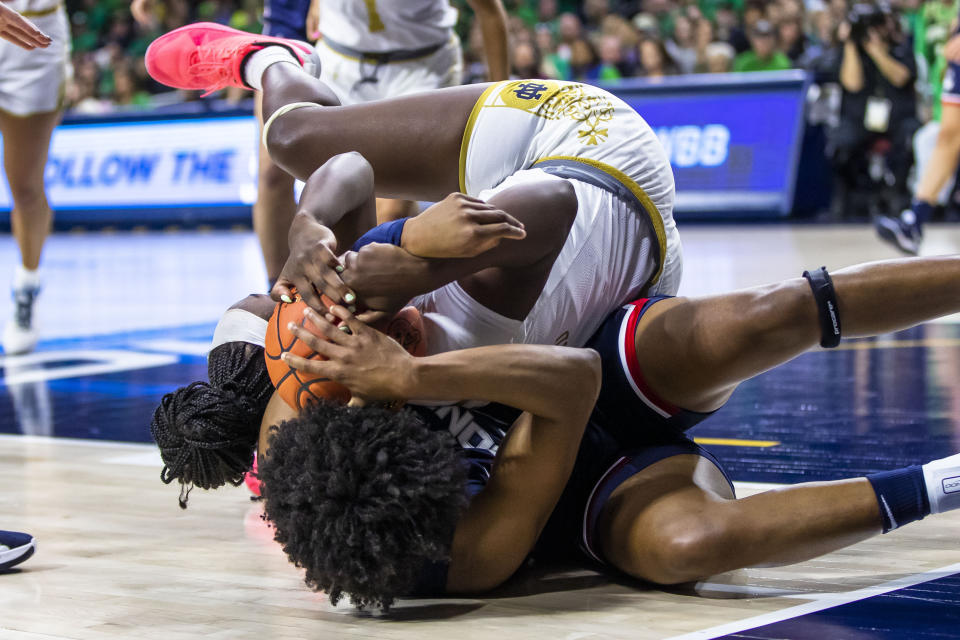 Notre Dame's KK Bransford, top, and Connecticut's Ayanna Patterson, bottom, fight for possession during the second half of an NCAA college basketball game on Sunday, Dec. 4, 2022, in South Bend, Ind. (AP Photo/Michael Caterina)