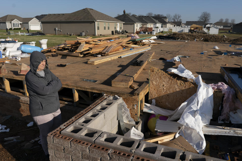 Ganimete Ademi surveys the debris from her daughter's house which was being built along Moss Creek Avenue in Bowling Green, Ky., Tuesday, Dec. 14, 2021. The neighborhood was one of the hardest hit areas in the city after a tornado ripped through the city the previous weekend. Ademi, a 46-year-old grandmother, fled Kosovo in 1999 during the war, in which she lost her uncle and a nephew. Now she looks around her own neighborhood. “I turn my memory back to 22 years ago,” she said. (AP Photo/James Kenney)