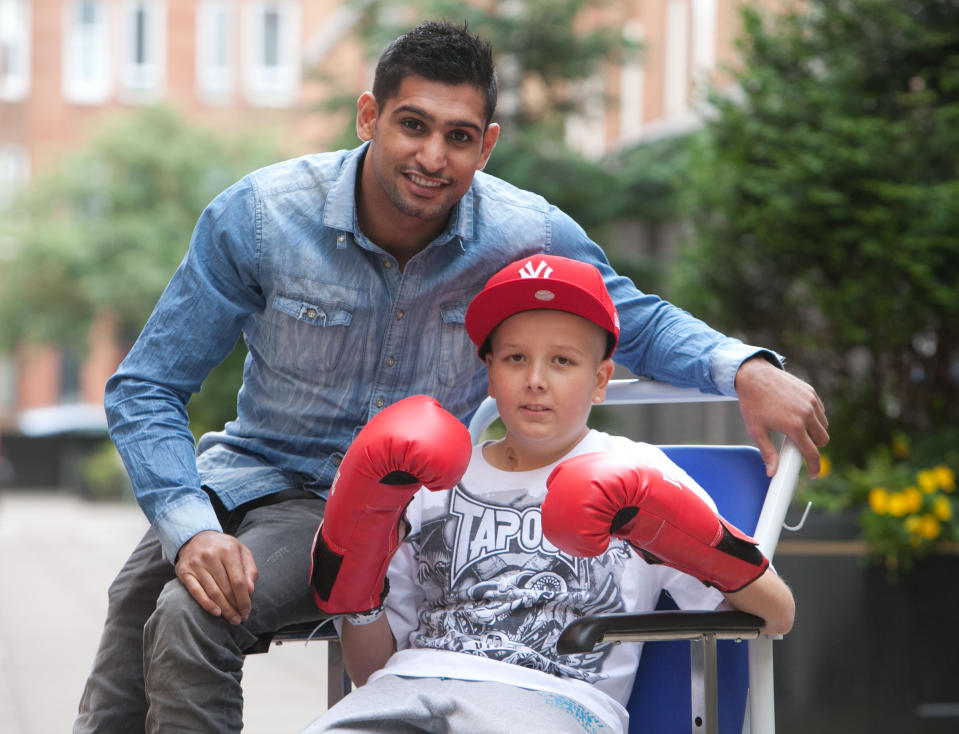 British boxer Amir Khan with Michael Glen (11), Shamerr Rehman (12) and Jack Glen (8) during a visit to patients at Glasgow's Royal Hospital for Sick Kids at Yorkhill, Glasgow.