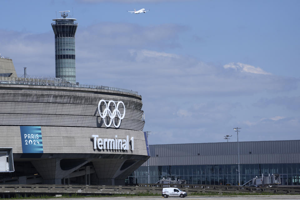 A plane takes off from Charles de Gaulle airport where the olympic rings were installed on terminal 1, in Roissy-en-France, north of Paris, Tuesday, April 23, 2024 in Paris. (AP Photo/Thibault Camus)