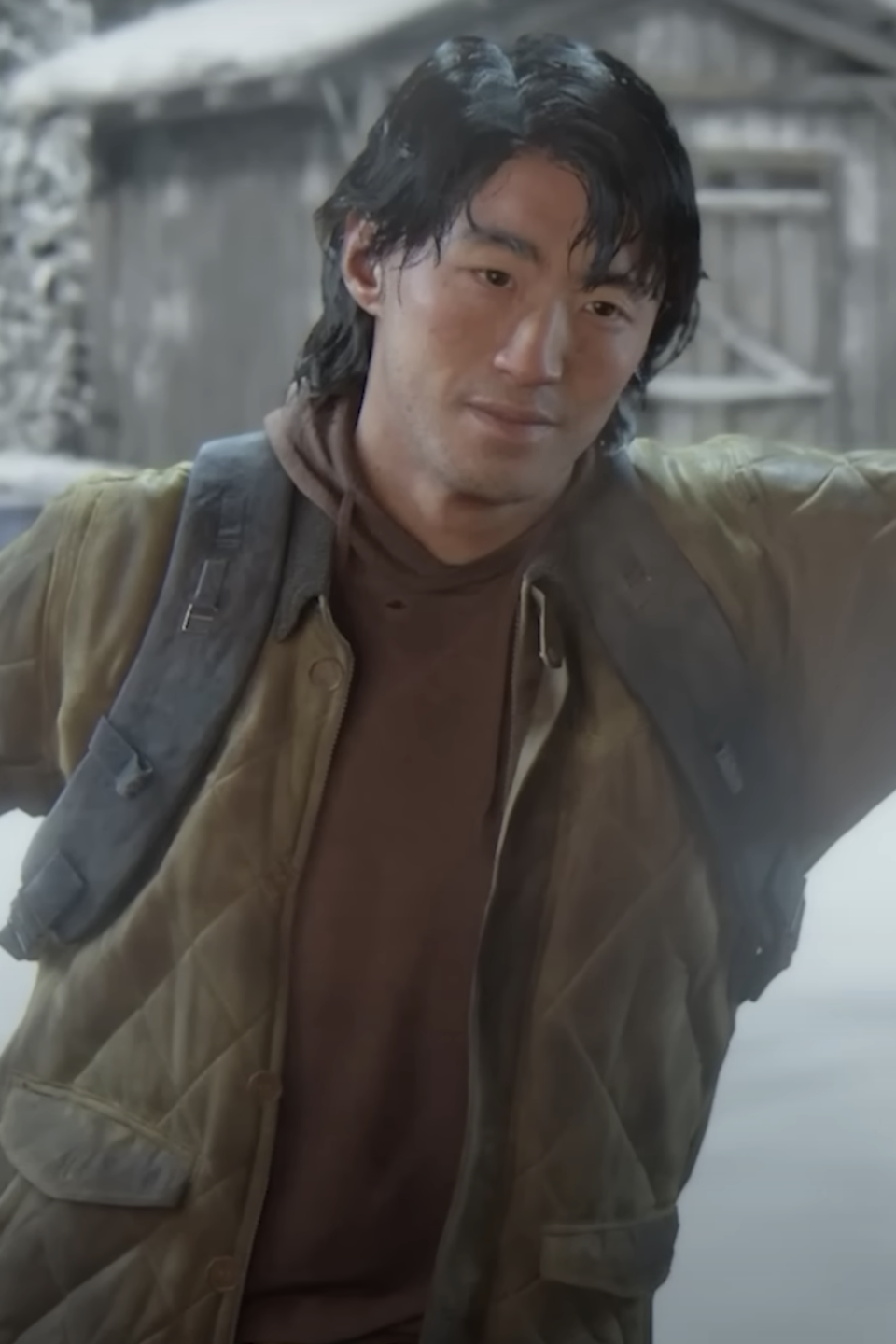 Jesse in The Last of Us in a winter setting wearing a quilted jacket and looking toward the viewer