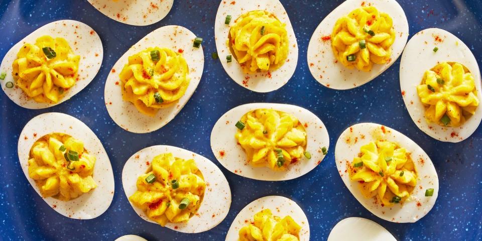 deviled eggs piped in a star shape with paprika and chives