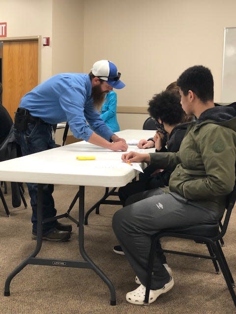 Dominion field technician Justin Leonard shows Grier Middle School students what to measure during math discussion.