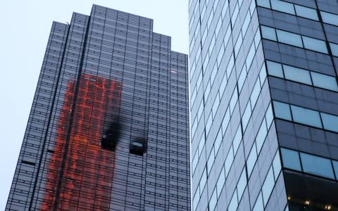 Damaged windows are seen after a fire in a residential unit at Trump Tower in New York - Credit: Reuters