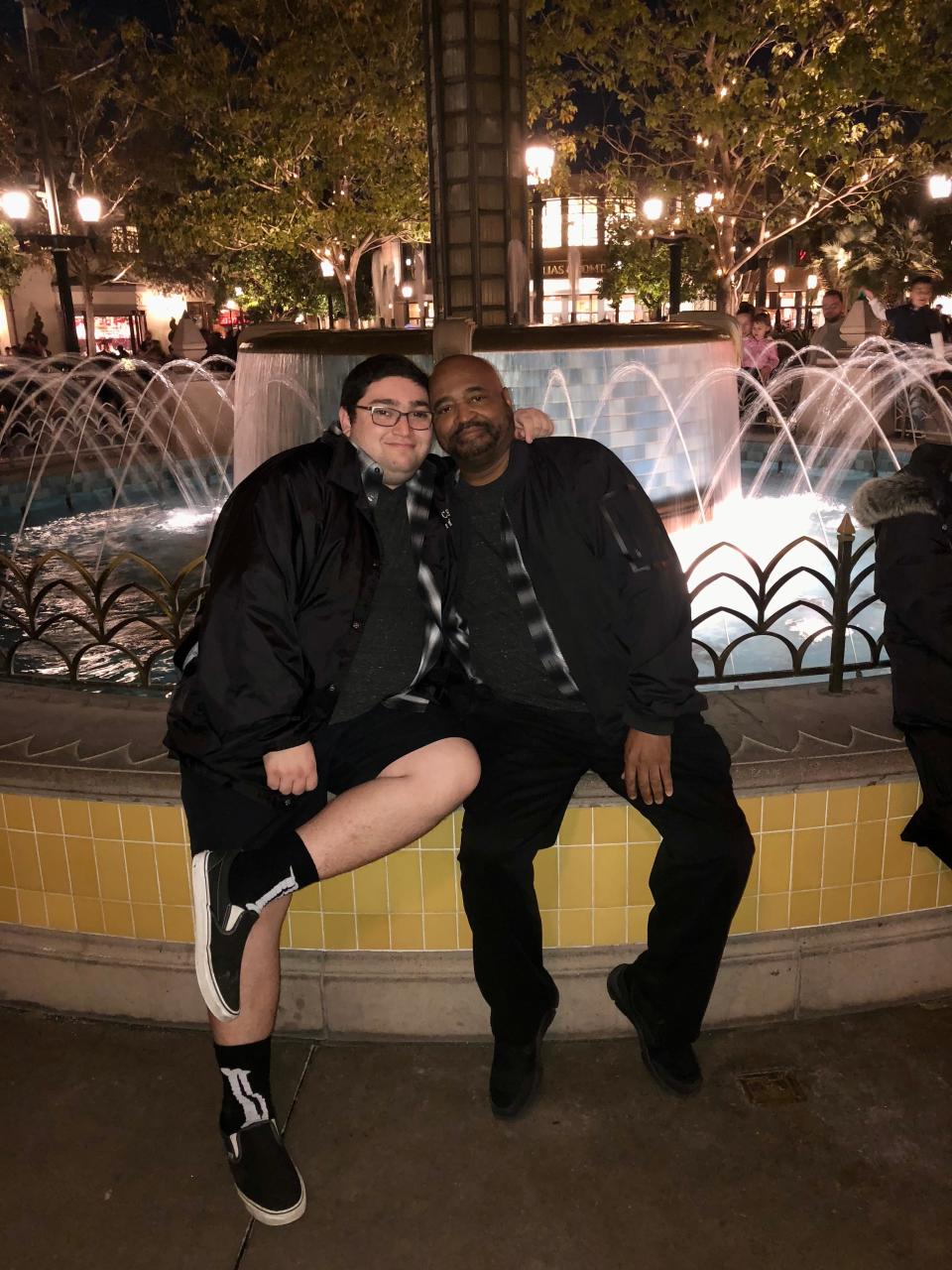 The author (left) and his partner, sitting on the edge of a fountain at night.