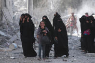 <p>A girl reacts while walking with women after they were evacuated with others by the Syria Democratic Forces (SDF) fighters from an Islamic State-controlled neighbourhood of Manbij, in Aleppo Governorate, Syria, Aug. 12, 2016. (REUTERS/Rodi Said) </p>