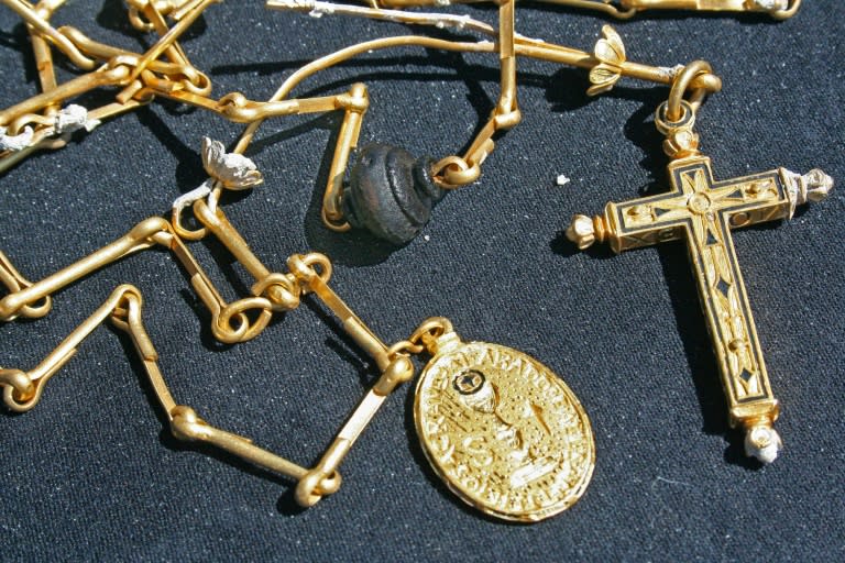 This photo, released by the Florida Keys News Bureau, shows a centuries-old, 40-inch-long (101.6-cm) gold chain with religious pendants found on March 23, 2011, by diver Bill Burt, of Mel Fisher's Treasures