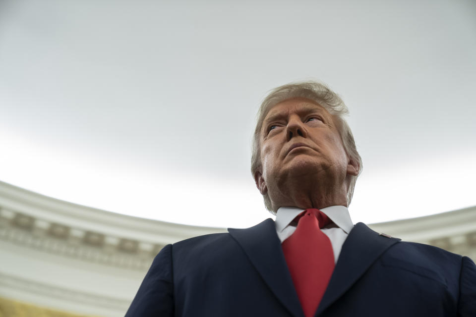 President Donald Trump listens during a ceremony to present the Presidential Medal of Freedom to former football coach Lou Holtz, in the Oval Office of the White House, Thursday, Dec. 3, 2020, in Washington. (AP Photo/Evan Vucci)