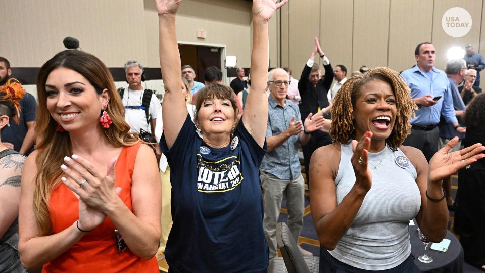 Calley Malloy, left, of Shawnee, Kan.; Cassie Woolworth of Olathe, Kan.; and Dawn Rattan, right, of Shawnee, Kan., applaud during a primary watch party on Aug. 2 in Overland Park, Kan.