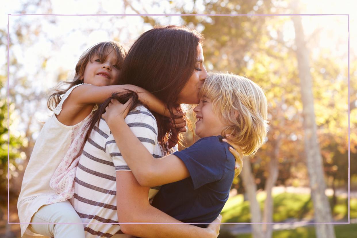  Mother with her two children in a park. 