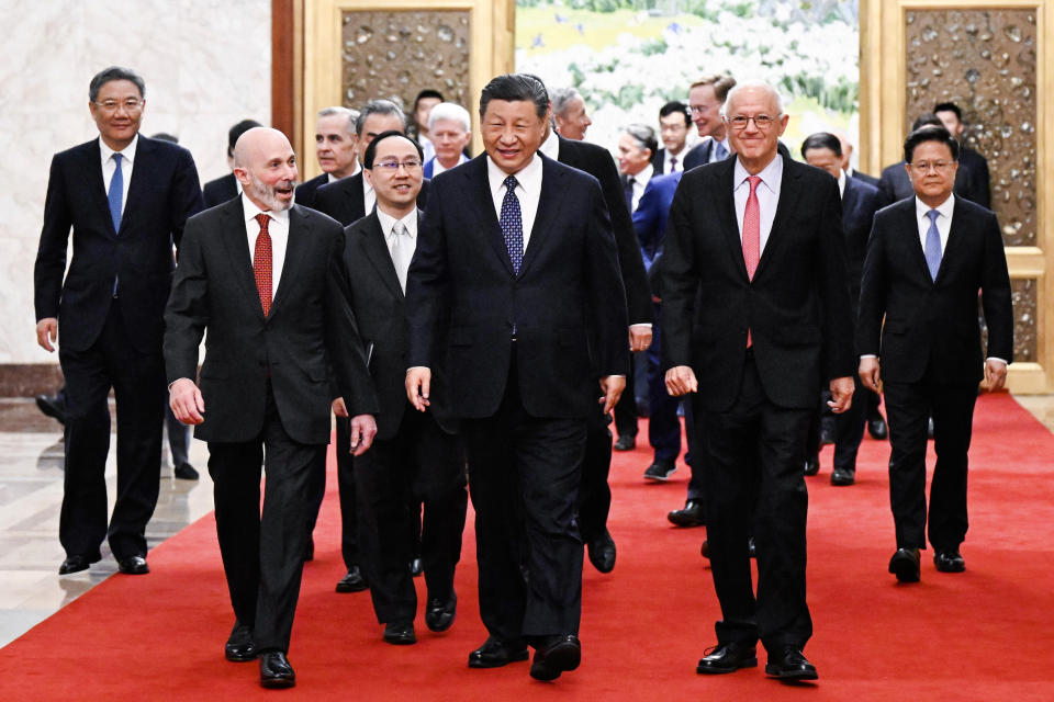 In this photo released by Xinhua News Agency, Chinese President Xi Jinping, center, walks with representatives from American business, strategic and academic communities at the Great Hall of the People in Beijing, March 27, 2024. (Shen Hong/Xinhua via AP)