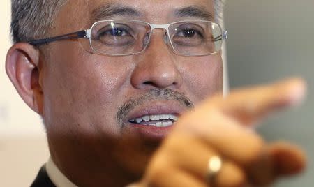 Managing Director of Kazanah Nasional Berhad Tan Sri Dato' Azman Mokhtar gestures during a news conference to announce Malaysia Airlines' restructuring plans, at Petronas Towers in Kuala Lumpur, August 29, 2014. REUTERS/Olivia Harris