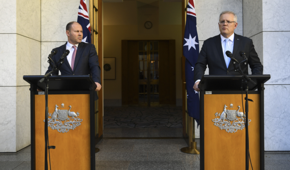 Treasurer Josh Frydenberg and Prime Minister Scott Morrison stand at podium and announce travel ban for non-Australian citizens.