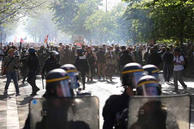 Protesters face anti-riot police in Paris as striking rail workers, civil servants and students demonstrated across France against Emmanuel Macron's public sector reforms but in markedly lower numbers than a month ago