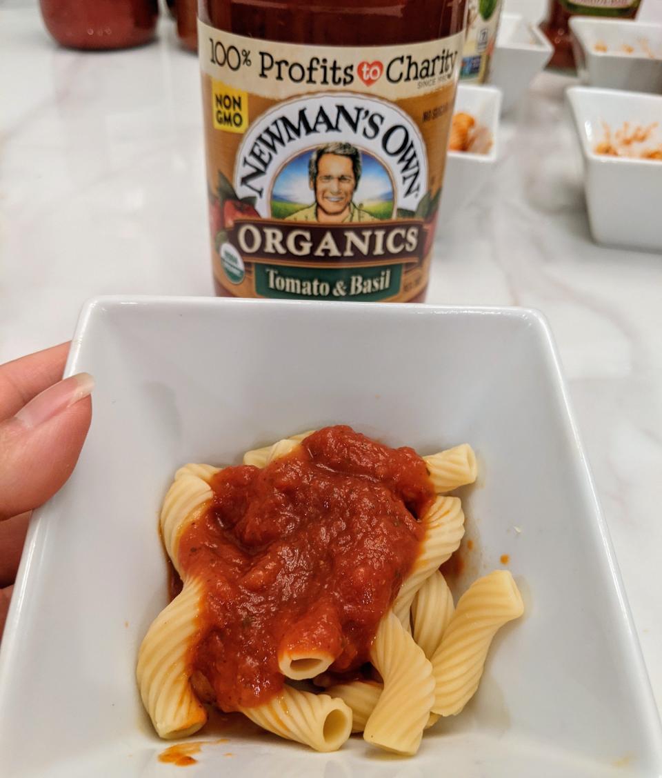 jar of newman's old red sauce behind a small white bowl of pasta