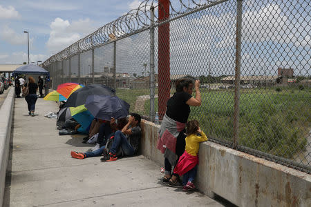 A Honduran mother and her 3-year-old daughter wait with fellow asylum seekers on the Mexican side of the Brownsville-Matamoros International Bridge after being denied entry by U.S. Customs and Border Protection officers near Brownsville. REUTERS/Loren Elliott