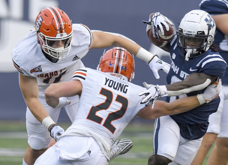 Utah State running back Davon Booth (6) carries the ball as Idaho State linebacker Nathan Reynolds, left, and safety Mason Young (22) defend during the first half of an NCAA college football game Saturday, Sept. 9, 2023, in Logan, Utah. | Eli Lucero/The Herald Journal via AP