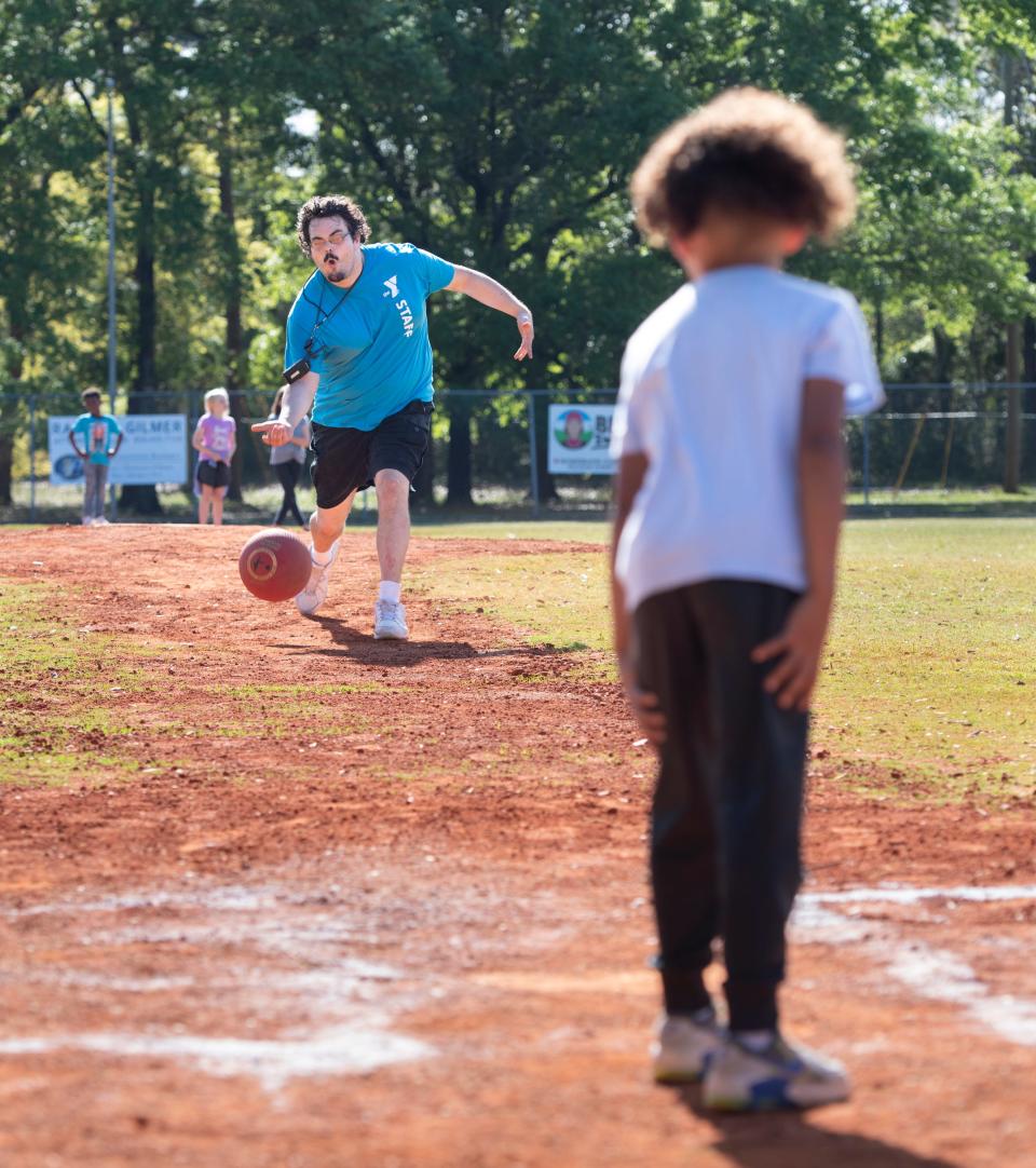 Counselor Thomas Owen pitches a kickball during the YMCA afterschool program at the Vickrey Community Center in Pensacola on Tuesday.