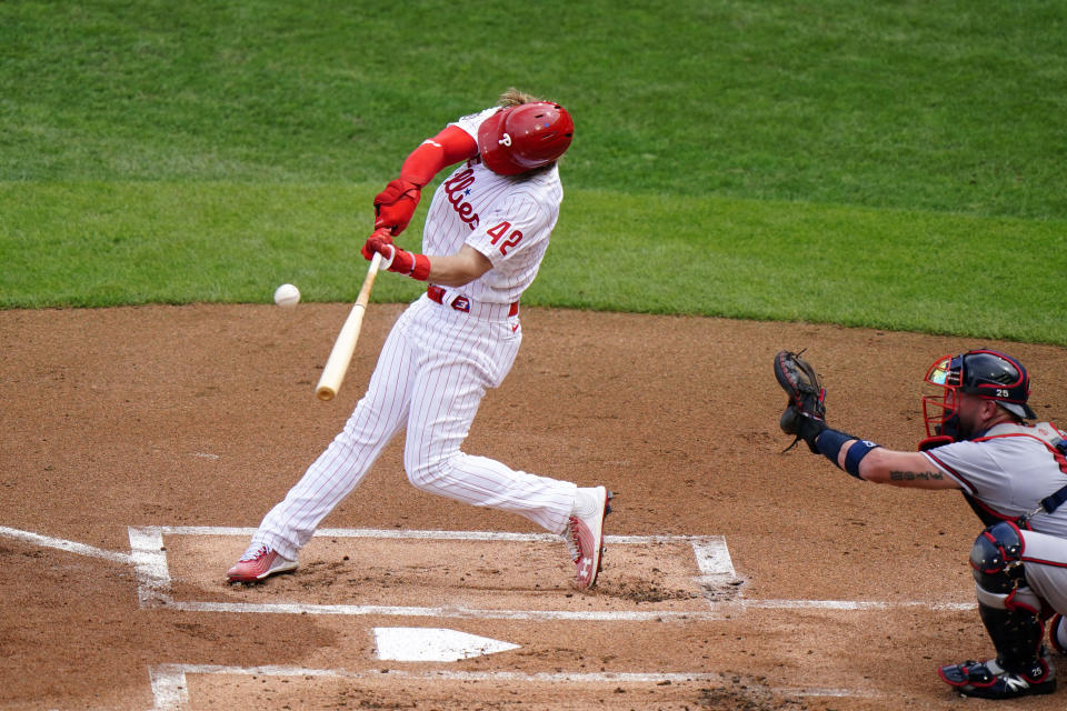 Philadelphia Phillies' Bryce Harper hits an RBI-sacrifice fly off Atlanta Braves pitcher Josh Tomlin during the first inning of a baseball game, Saturday, Aug. 29, 2020, in Philadelphia. (AP Photo/Matt Slocum)