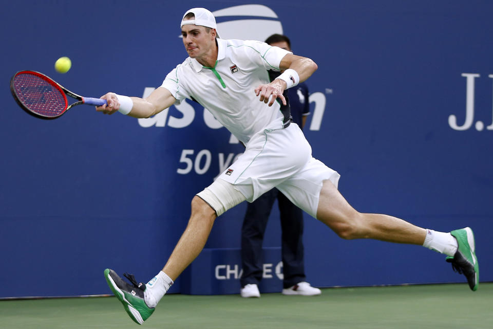 John Isner, of the United States, returns a shot to Milos Raonic, of Canada, during the fourth round of the U.S. Open tennis tournament, Sunday, Sept. 2, 2018, in New York. (AP Photo/Jason DeCrow)