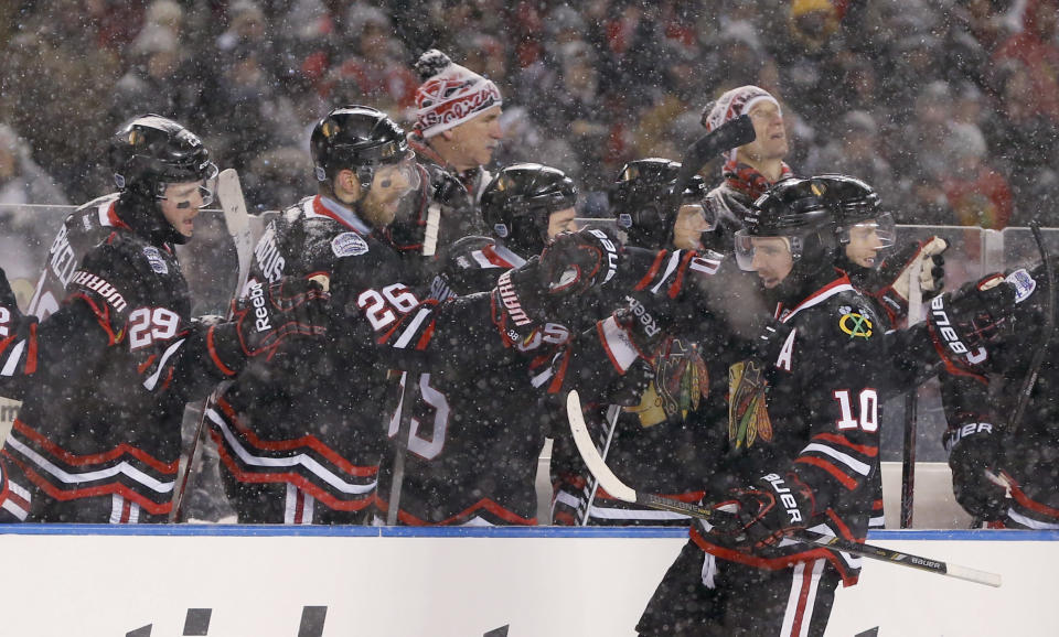 Chicago Blackhawks left wing Patrick Sharp (10) celebrates his goal with teammates on the bench during the first period of an NHL Stadium Series hockey game against the Pittsburgh Penguins at Soldier Field on Saturday, March 1, 2014, in Chicago. (AP Photo/Charles Rex Arbogast)