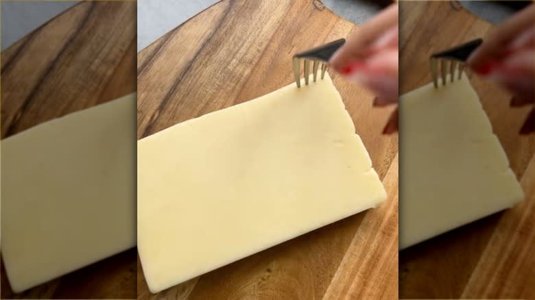 making holes in cheese with fork