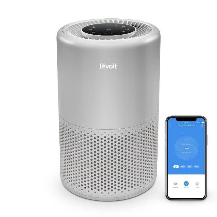 A close up of the air purifier and the accompanying app on a smartphone