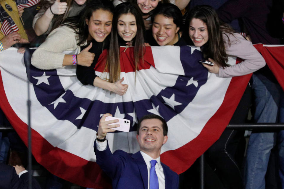 Four grinning young women in selfie with Pete Buttigieg. 