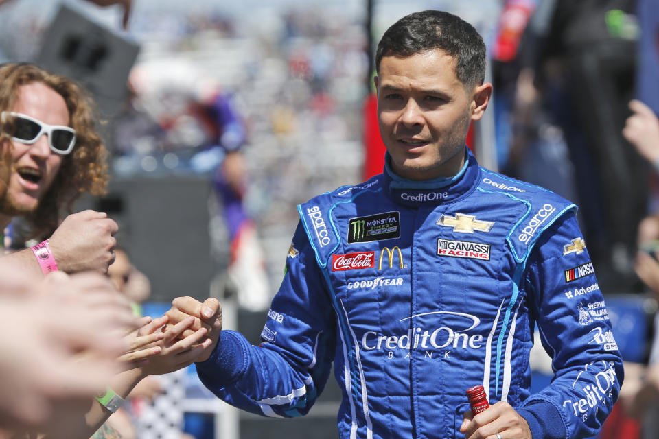 FILE - In this March 24, 2019, file photo, NASCAR Cup Series driver Kyle Larson (42) greets fans during driver introductions prior to the NASCAR Cup Series auto race at the Martinsville Speedway in Martinsville, Va. Larson will be back in NASCAR next season driving the flagship No. 5 Chevrolet for Hendrick Motorsports. Larson signed a multi-year contract Wednesday morning with Hendrick that ended his seven-month banishment from NASCAR for using a racial slur while playing an online racing game.(AP Photo/Steve Helber, File)