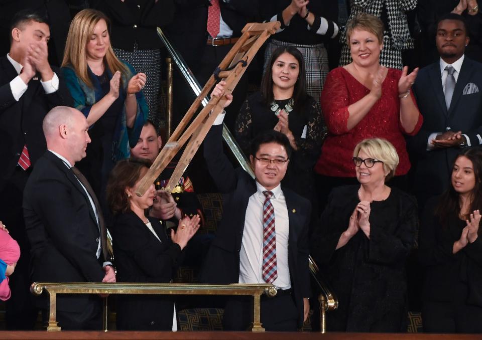 <p>North Korean defector Ji Seong-ho raises his crutches as Trump delivers the State of the Union address at the U.S. Capitol in Washington, D.C., on Jan. 30. (Photo: Saul Loeb/AFP/Getty Images) </p>