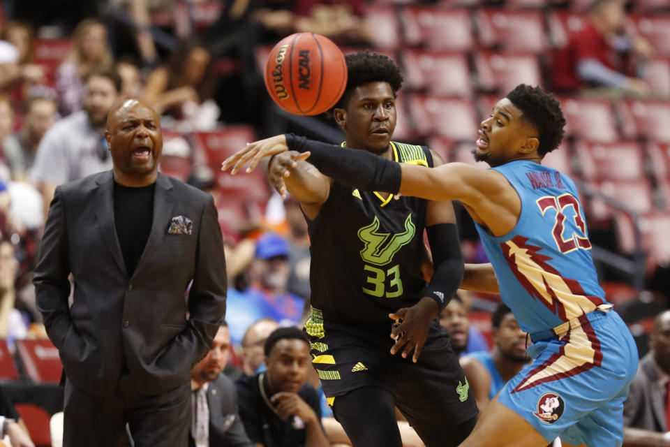 South Florida forward B.J. Mack (33) passes past Florida State guard M.J. Walker (23) as Florida State head coach Leonard Hamilton, left, yells out in the first half of an NCAA college basketball game, part of the Orange Bowl Classic tournament, Saturday, Dec. 21, 2019, in Sunrise, Fla. (AP Photo/Wilfredo Lee)