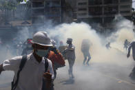 Anti-coup protesters run away from tear gas launched by security forces in Yangon, Myanmar, Monday, March 1, 2021. Defiant crowds returned to the streets of Myanmar's biggest city on Monday, determined to continue their protests against the military's seizure of power a month ago, despite security forces having killed at least 18 people around the country just a day earlier. (AP Photo)