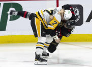 Ottawa Senators center Mark Kastelic, right, fights with Pittsburgh Penguins defenseman John Ludvig during the first period of an NHL hockey game, Tuesday, March 12, 2024, Ottawa, Ontario. (Adrian Wyld/The Canadian Press via AP)