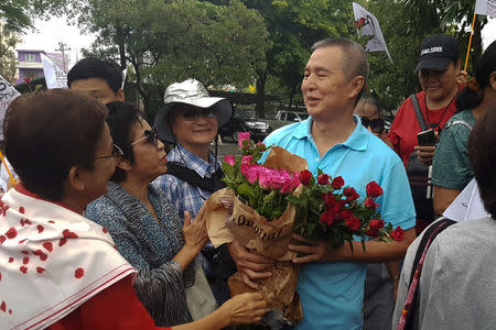 Somyot Prueksakasemsuk, 56, a high-profile Thai activist and former magazine editor jailed for insulting the country's monarchy, receives roses from his supporters after his release from a Bangkok prison in Thailand, April 30, 2018. REUTERS/Aukkarapon Niyomat