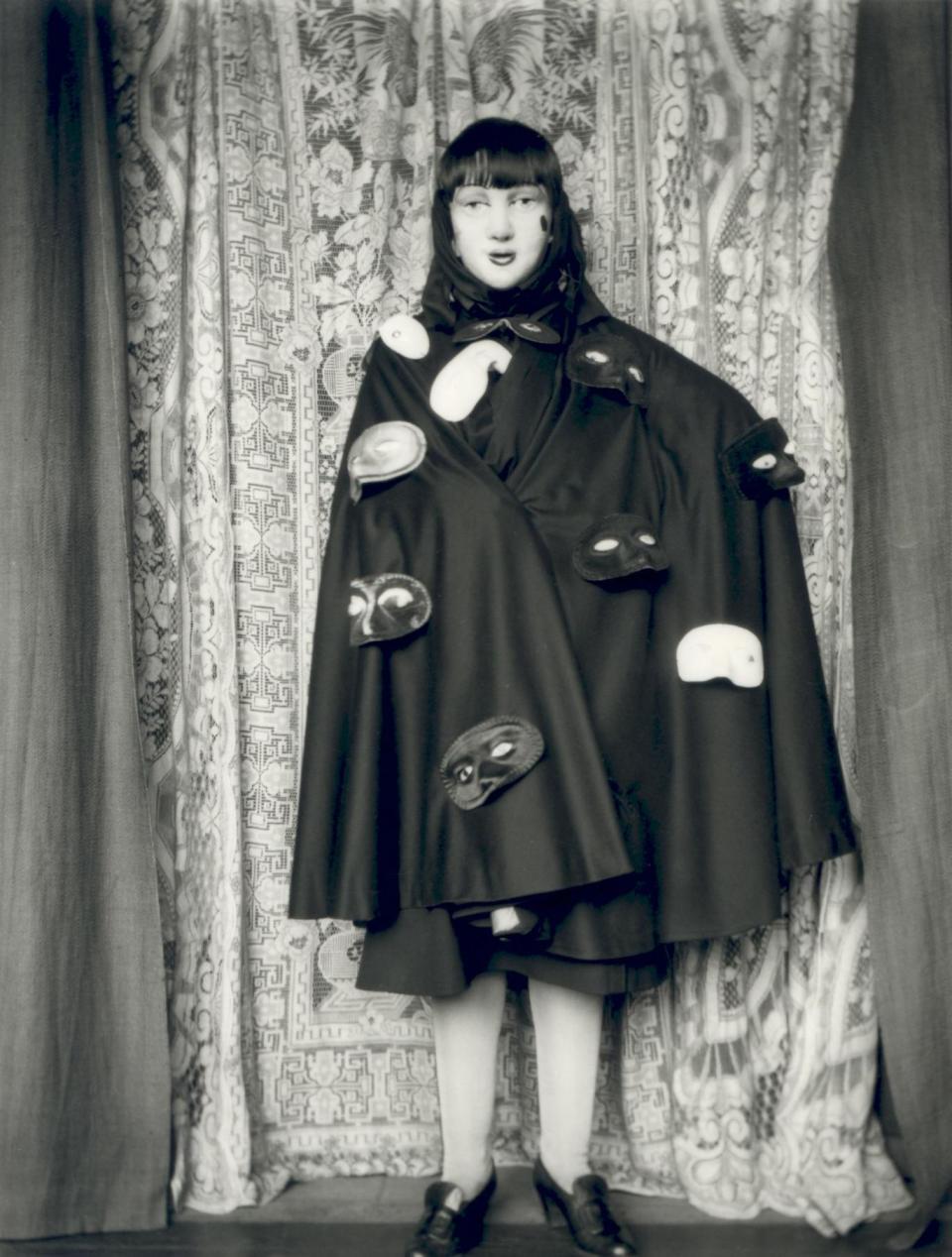 'Self-portrait (full length masked figure in cloak with masks)' by Claude Cahun, 1928 (© Jersey Heritage)