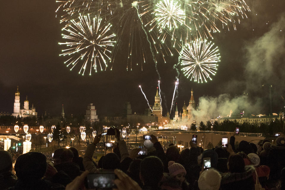 <p>People take pictures as fireworks explode over the Kremlin, during New Year celebrations in Moscow, Russia, Monday, Jan. 1, 2018. New Year is Russia’s major gift-giving holiday. (Photo: Denis Tyrin/AP) </p>