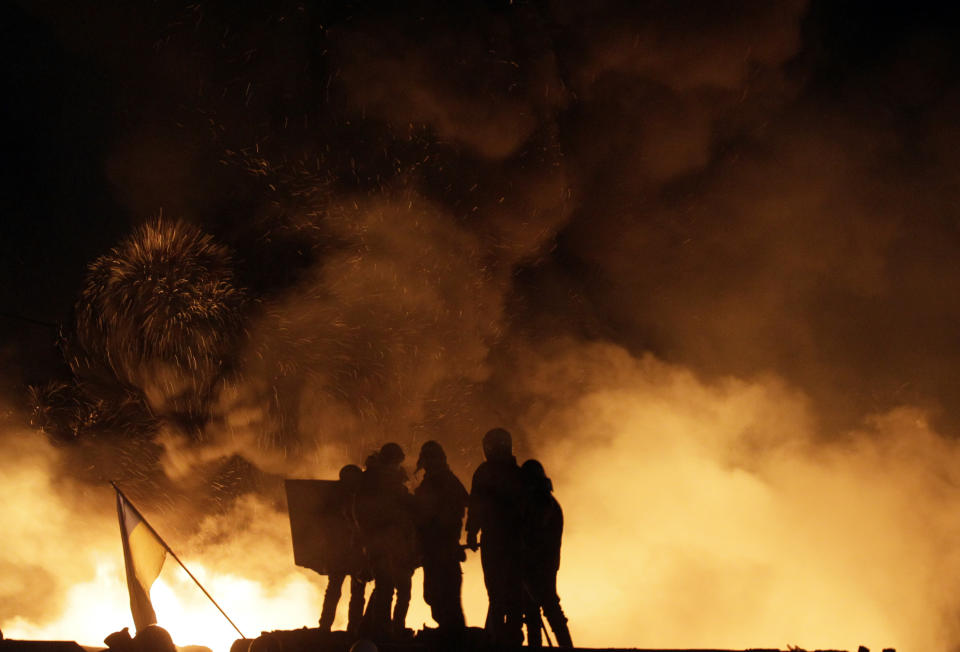 Protesters confront police in central Kiev, Ukraine, Friday Jan. 24, 2014. As riots spread from Ukraine's embattled capital to nearly half of the country, President Viktor Yanukovych promised Friday to reshuffle his government and make other concessions — but a top opposition leader said nothing short of his resignation would do. Hours after the president's comments, huge fireballs lit up the night sky in central Kiev and plumes of thick black smoke rose from burning tires at giant barricades erected by protesters. (AP Photo/Darko Vojinovic)