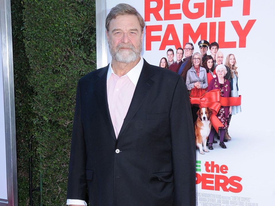 John Goodman wearing a black suit and a light pink shirt at the Premiere of 'Love The Coopers' in November 2015