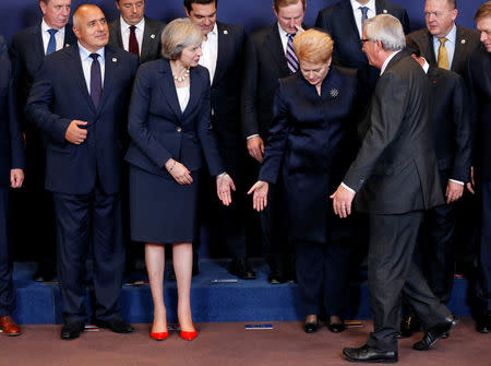 European Commission President Jean-Claude Juncker arrives to pose between Britain's Prime Minister Theresa May and Lithuania's President Dalia Grybauskaite during a European Union leaders summit in Brussels, Belgium, October 20, 2016. REUTERS/Francois Lenoir