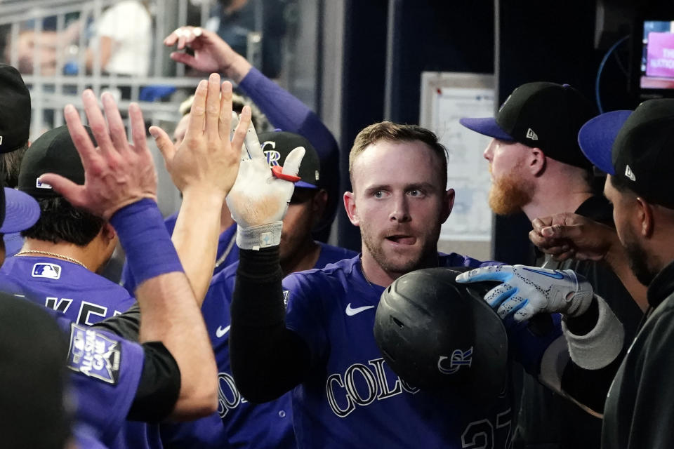 Colorado Rockies shortstop Trevor Story celebrates in the dugout after hitting a solo home run in the first inning of a baseball game against the Atlanta Braves Tuesday, Sept. 14, 2021, in Atlanta. (AP Photo/John Bazemore)