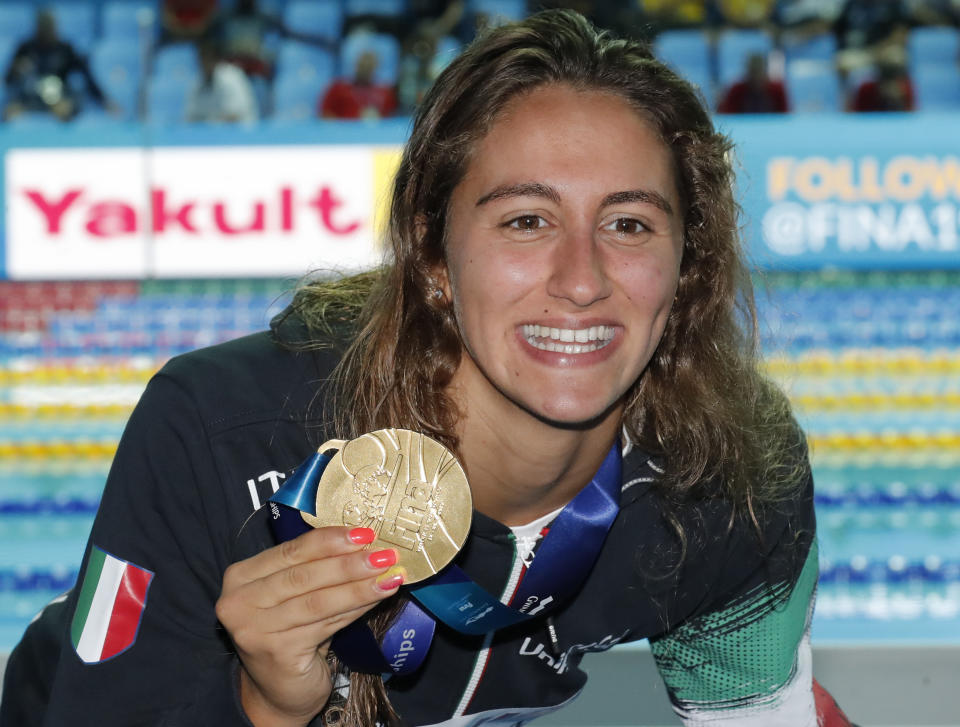 FILE - In this July 23, 2019 file photo, Italy's Simona Quadarella poses with her gold medal after winning the women's 1500m freestyle final at the World Swimming Championships in Gwangju, South Korea. A large portion of the Italian swimming team, 13 elite athletes, including Quadarella, has been locked in their tiny hotel rooms at a high-altitude training camp in the Alps for nearly two weeks with the coronavirus. (AP Photo/Lee Jin-man, file)
