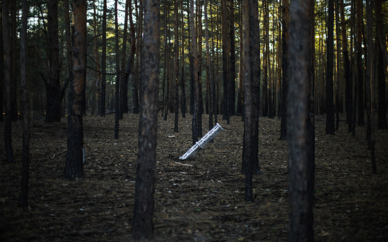 A Russian rocket sticks out of the ground in a forest