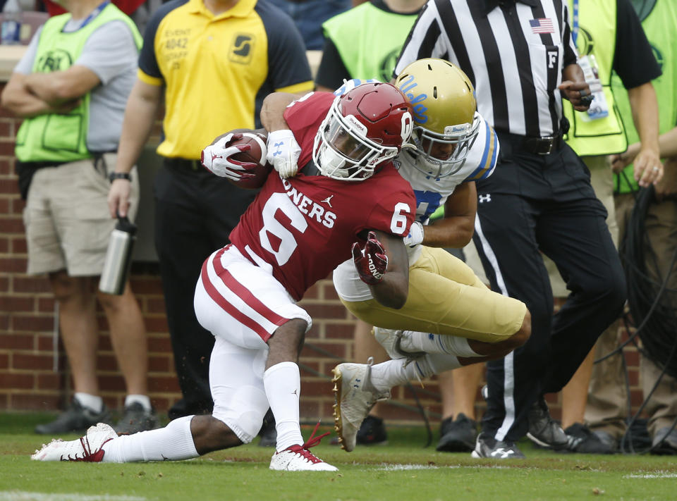 Oklahoma cornerback Tre Brown (6) is brought down by UCLA defensive back Nate Meadors (22) after an 86 yard kick off return in the first quarter of an NCAA college football game in Norman, Okla., Saturday, Sept. 8, 2018. (AP Photo/Sue Ogrocki)