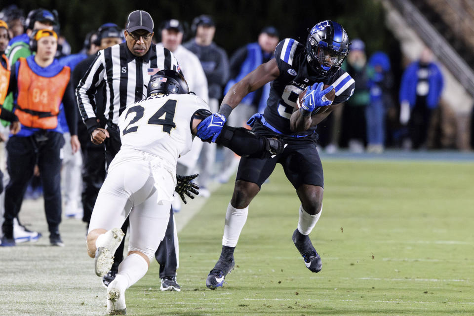 Duke's Jaquez Moore (9) carries the ball past Wake Forest's Dylan Hazen (24) during the first half of an NCAA college football game in Durham, N.C., Thursday, Nov. 2, 2023. (AP Photo/Ben McKeown)