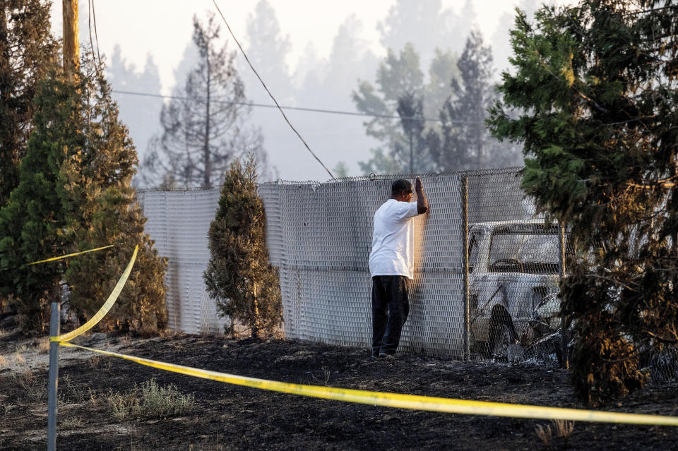 Dave Rodgers surveys his home, destroyed by the Mill Fire, on Saturday, Sept. 3, 2022, in Weed, Calif. Rodgers, who lived in the house his entire life, was able to take an elderly neighbor with him as he fled the fast-moving blaze but has not been able to find his two dogs that were left behind. (AP Photo/Noah Berger)