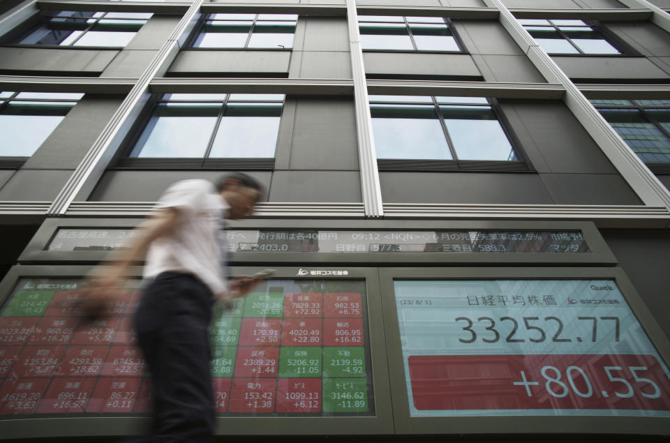 A man walks past monitors showing Japan's Nikkei 225 index at a securities firm in Tokyo, Tuesday, Aug. 1, 2023. Asian shares mostly rose Tuesday, boosted by market optimism set off by a Wall Street rally despite lingering worries about inflation and regional growth. (AP Photo/Hiro Komae)