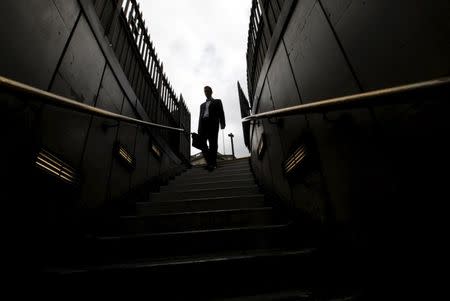 A man walks down steps into Bank tube station in the City of London, in this July 23, 2010 file photo. REUTERS/Andrew Winning/Files