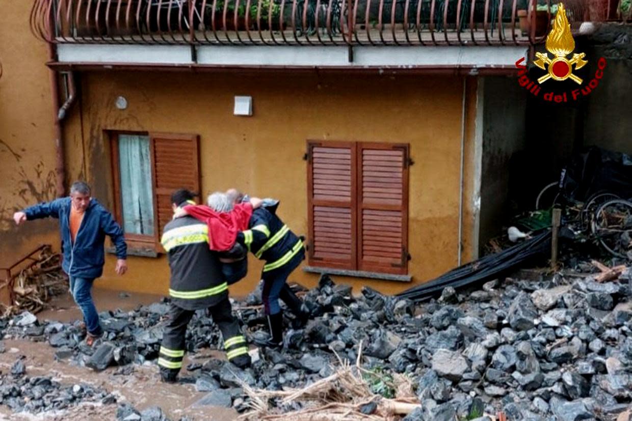 An elderly woman rescued by firefighters from her home  (Vigili del Fuoco via AP)